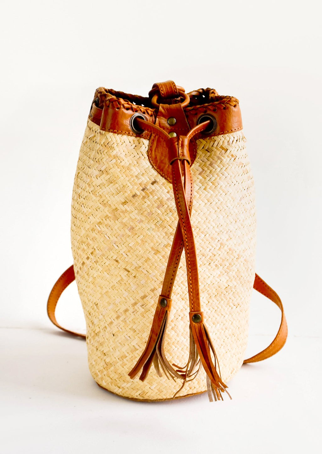 1: Tall and round woven straw bag with tanned leather details