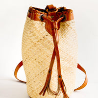 1: Tall and round woven straw bag with tanned leather details