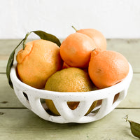 Small: A white ceramic fruit bowl with clementines.