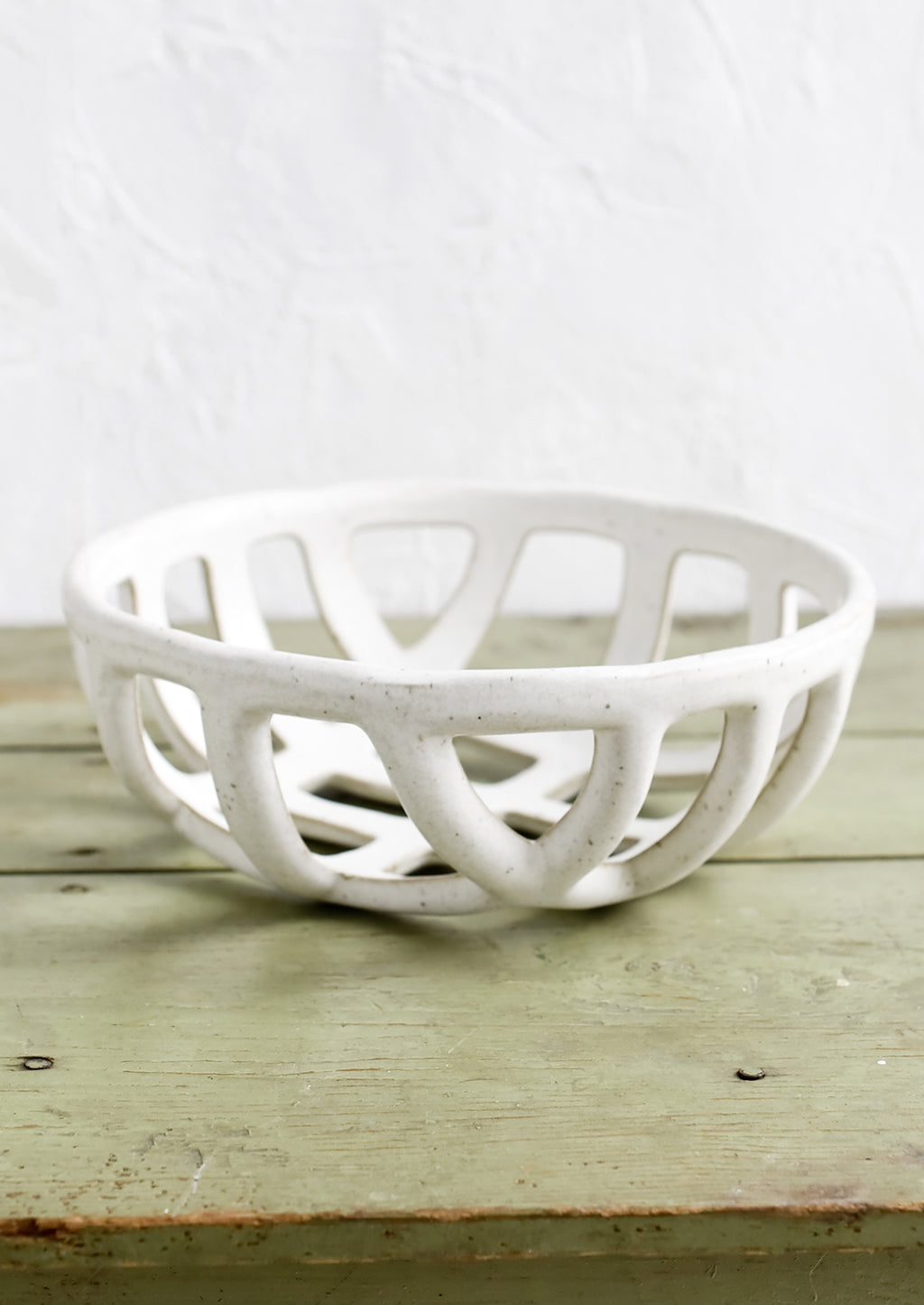 Large: A white ceramic fruit bowl with open weave design.