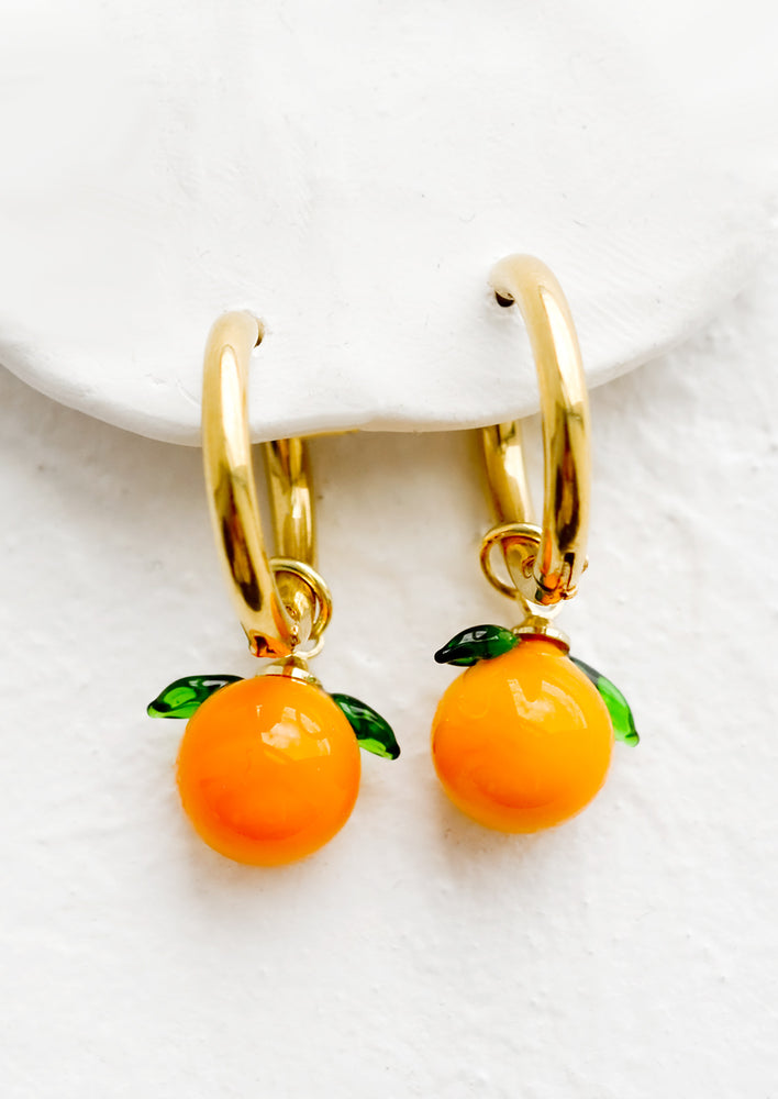 1: Gold huggie hoop earrings with glass tangerine charms.