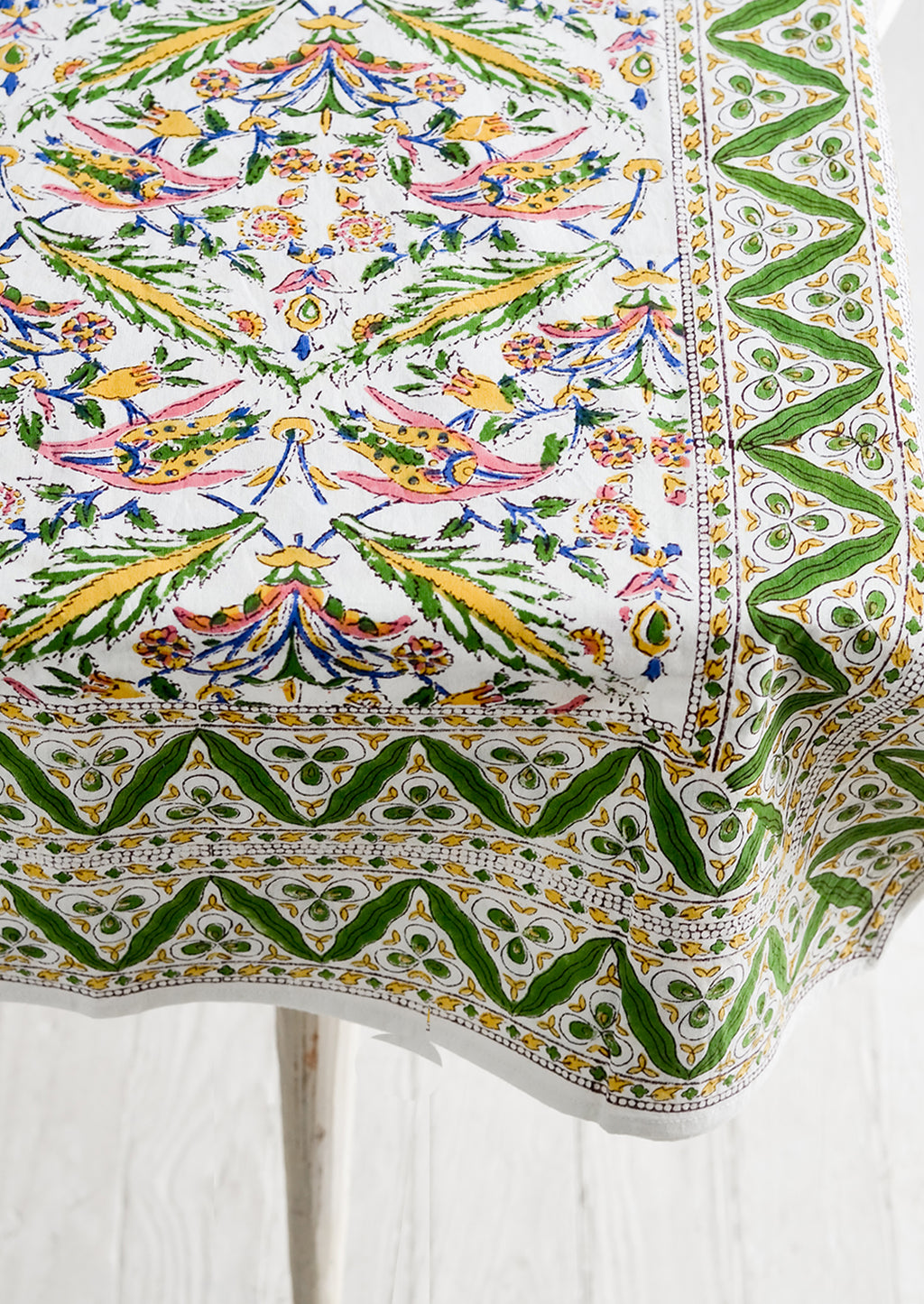 2: A block printed cotton tablecloth in vibrant green, pink and yellow floral pattern.