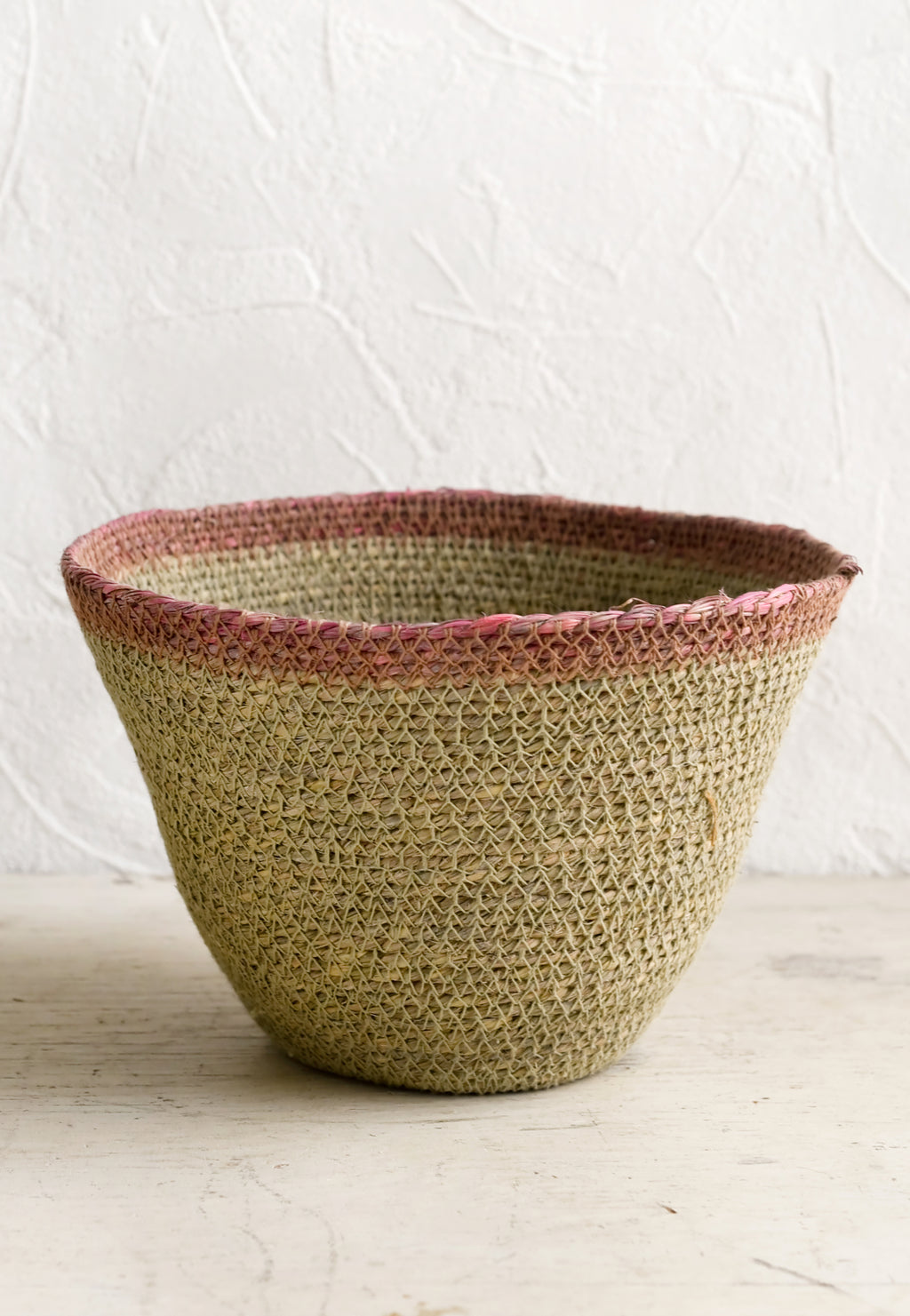 Natural / Rose: A tapered seagrass storage basket in natural with pink rim.