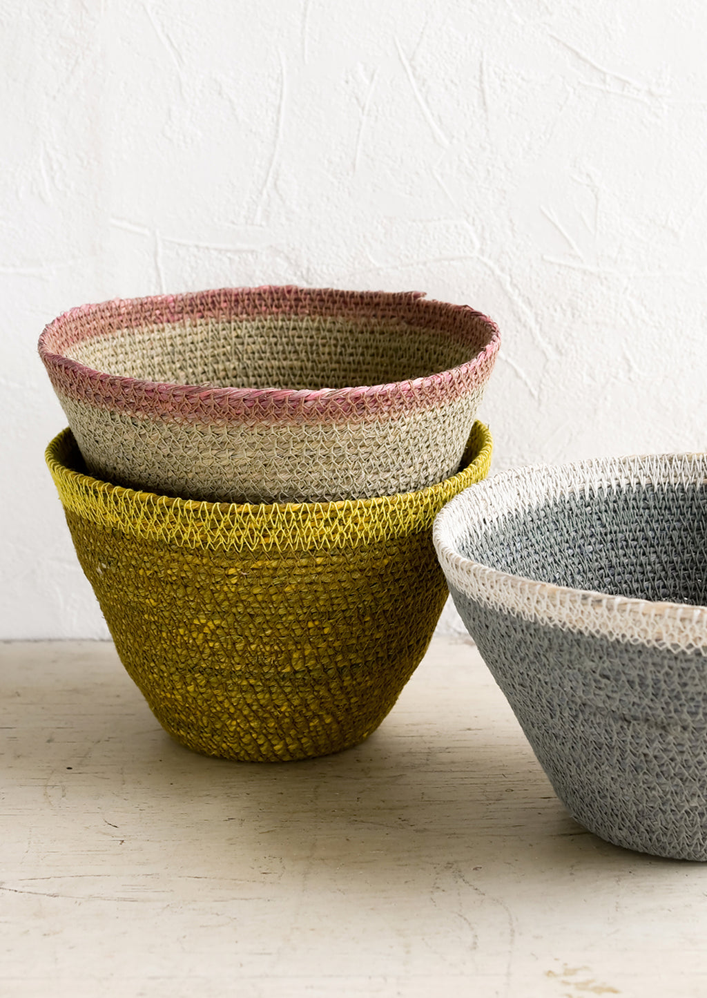2: Three tapered storage baskets in assorted colors.
