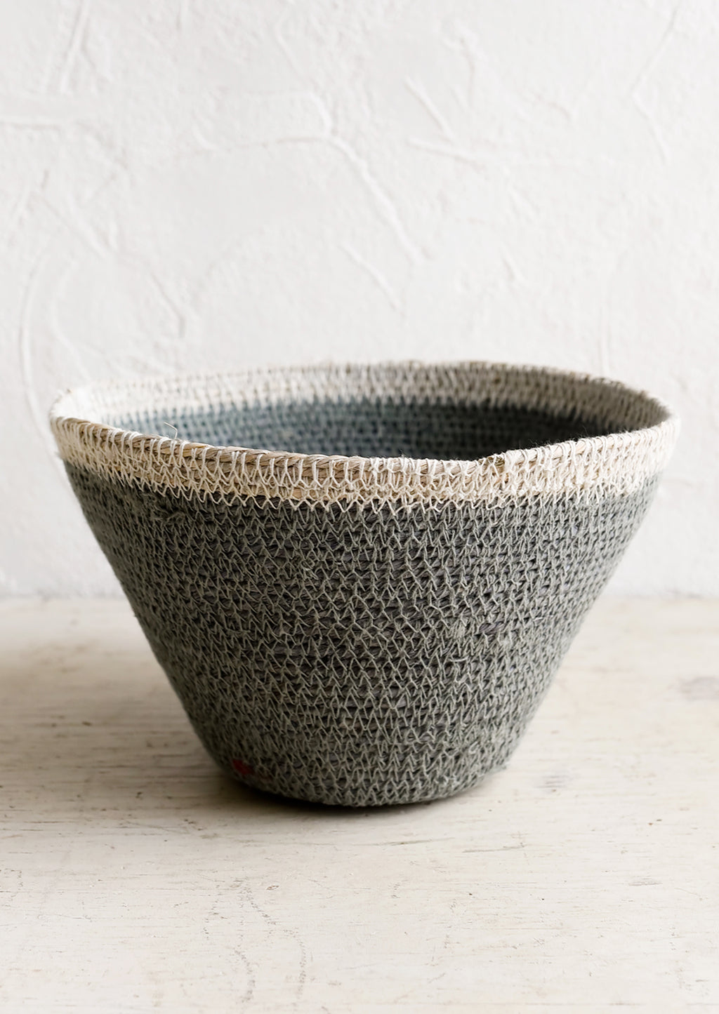 Dusty Blue / White: A tapered seagrass storage basket in dusty blue with white rim.