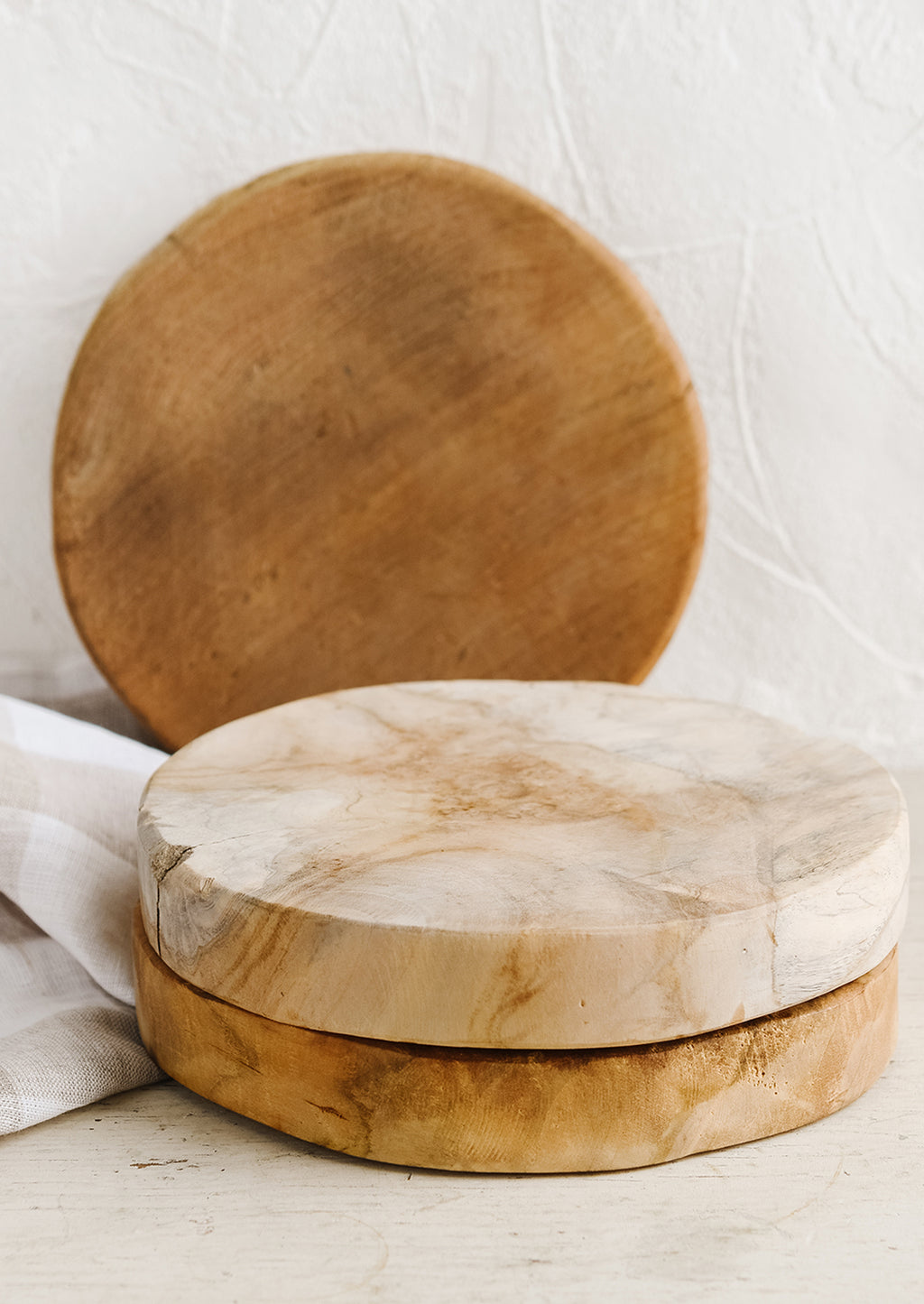 3: A round pedestal board made from natural teak.