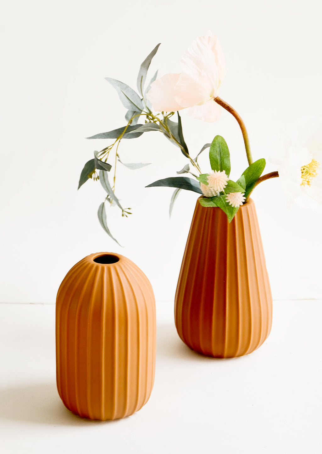 1: Terracotta colored ceramic vases with vertical ribbed texture