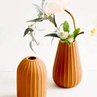 1: Terracotta colored ceramic vases with vertical ribbed texture
