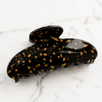Black / Toffee: A terrazzo hair claw in black with toffee spots.