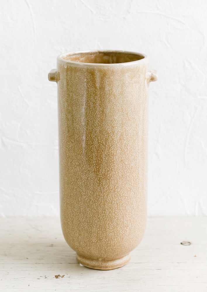 A tall, cylindrical ceramic vase in speckled brown glaze with decorative tab detailing at top.