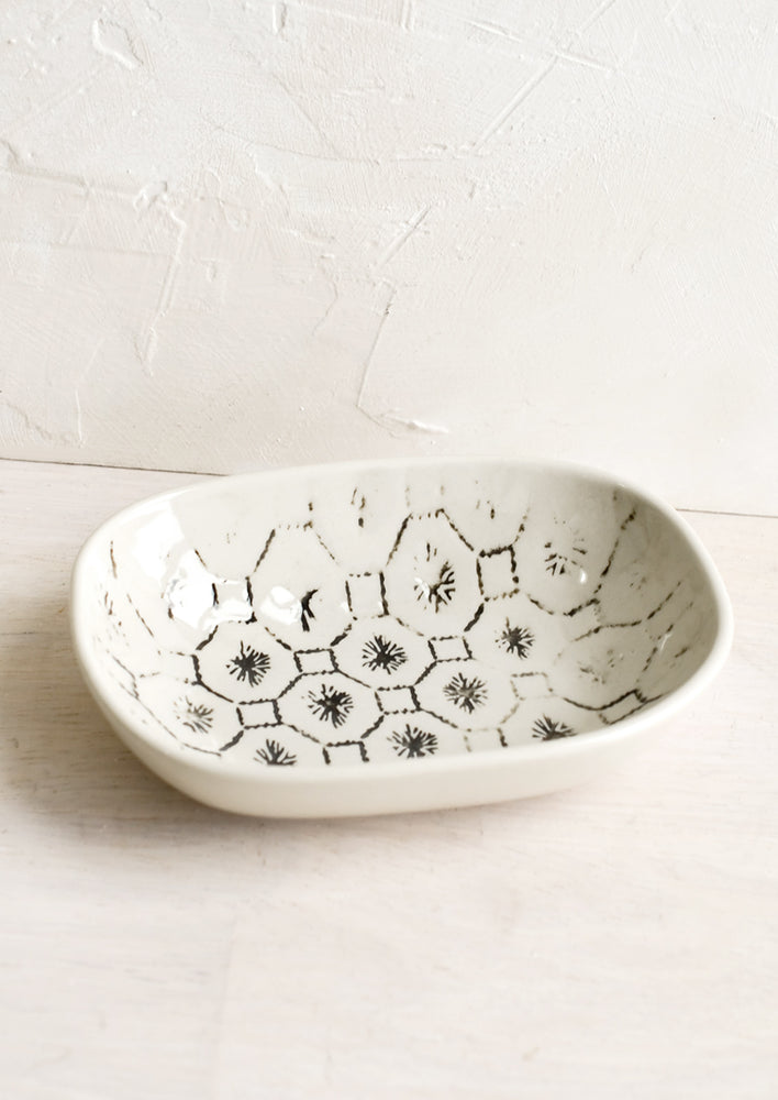 A small oval ceramic dish in hexagonal tile pattern.