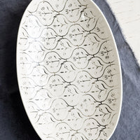 Small: A smaller oval shaped ceramic platter with black and white textile pattern.