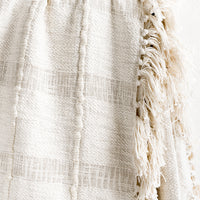 3: A natural cotton throw with paneling detailing and fringed trim.