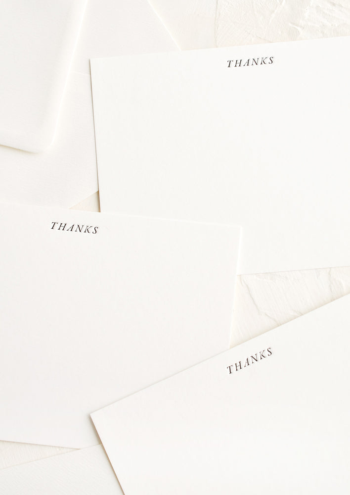 1: Three identical white notecards with letterpress printed "THANKS" text.