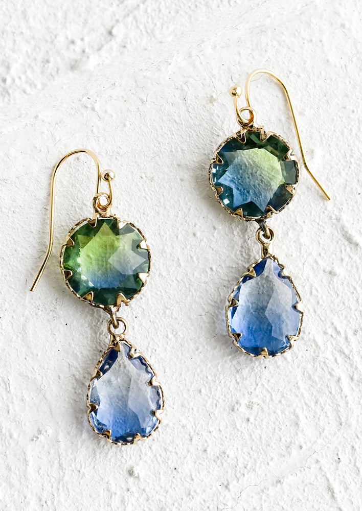 A pair of drop earrings with two green and blue glass stone crystals.