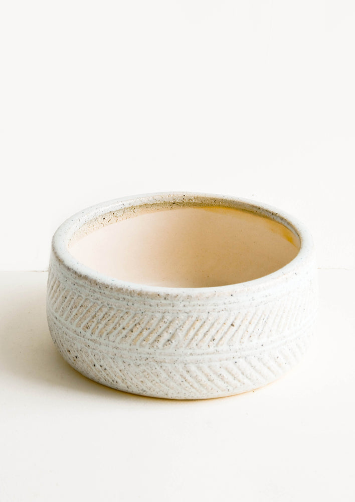 1: Shallow ceramic vessel designed for use as a planter, with herringbone textured exterior