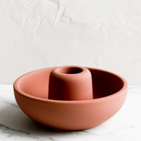 Dusty Terracotta: A matte taper candle holder with bowl-like base in dusty terracotta.