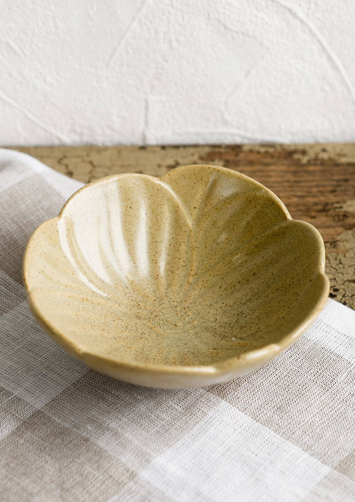 1: A tan ceramic flower shaped bowl.