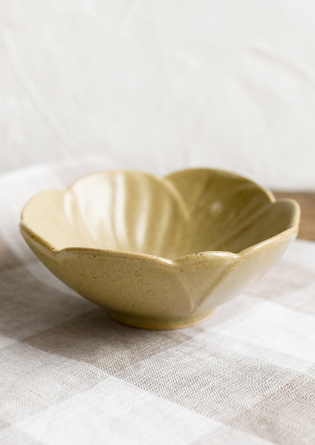 2: A tan ceramic flower shaped bowl.