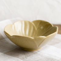 2: A tan ceramic flower shaped bowl.