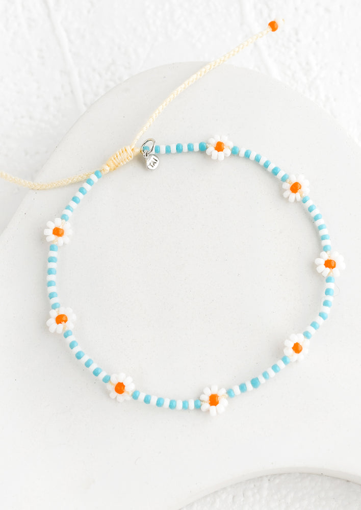 Sky Blue / Orange: A beaded bracelet in blue and white with orange flowers.