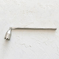 1: A pewter metal candle snuffer with abstract flower shape.