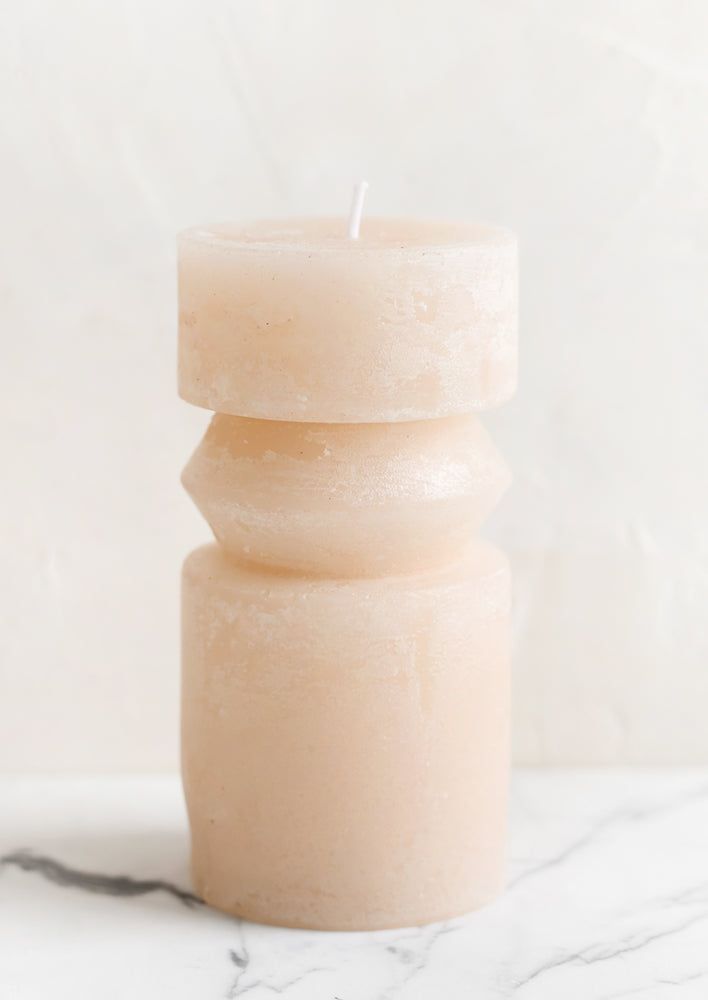 A medium carved pillar candle with waxy finish in petal pink.