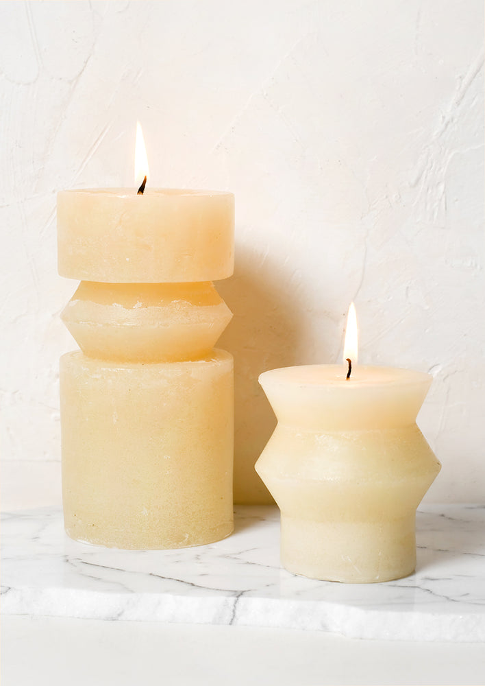 Vanilla colored pillar candles in assorted sizes.