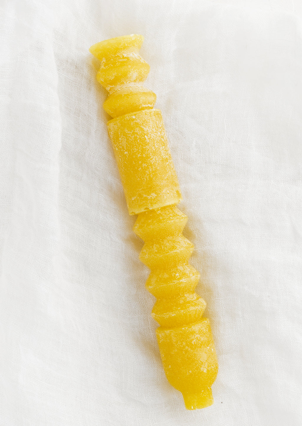 Beeswax: A geometric shape taper candle in beeswax (yellow).