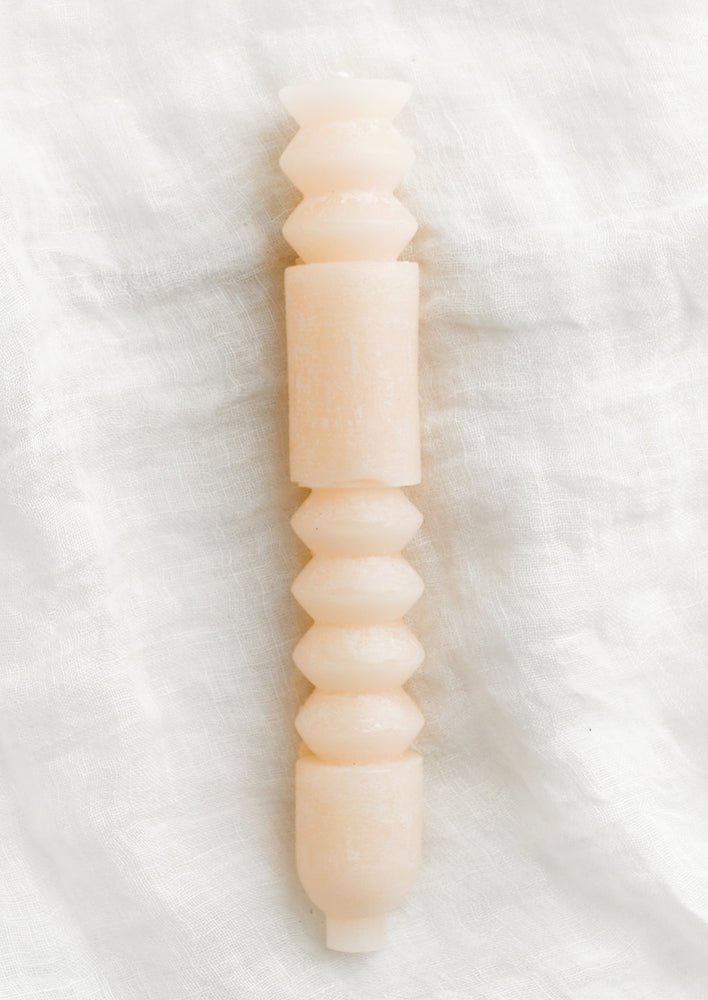 Petal: A geometric shape taper candle in petal (pale pink).
