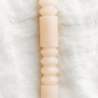 Petal: A geometric shape taper candle in petal (pale pink).