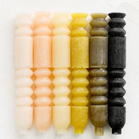 2: Carved geometric taper candles in assorted colors.
