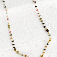 1: A long necklace with multicolor gemstones and tourmaline bezel.