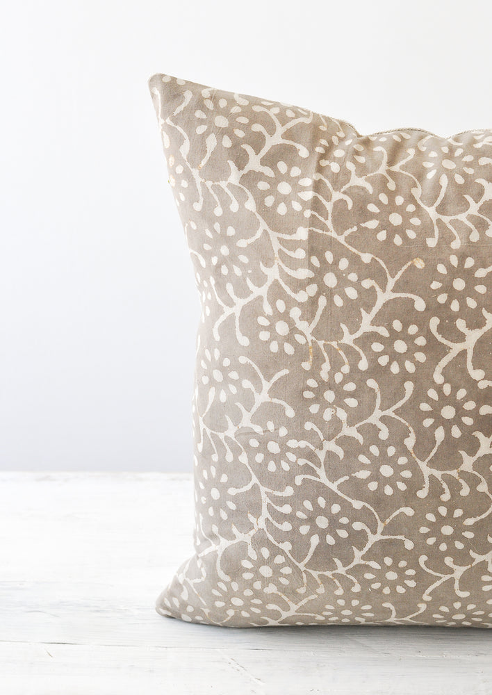 3: Detail shot of a grey and white floral block-printed square pillow.