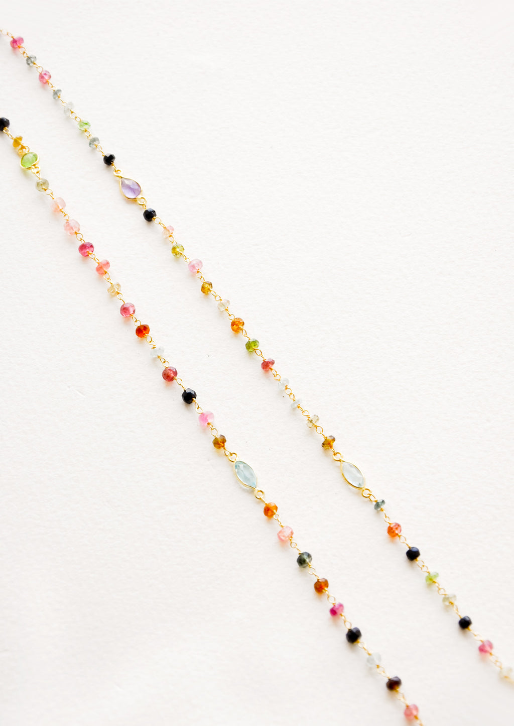 2: A long necklace with multicolor gemstones and tourmaline bezel.