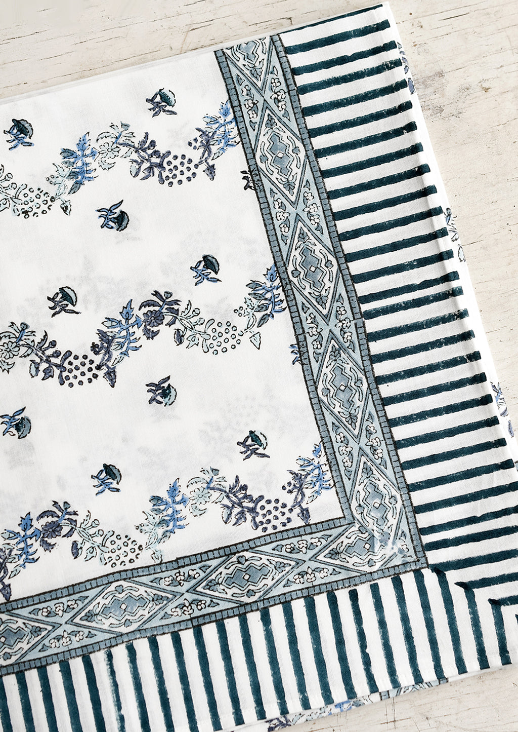 1: A block printed floral tablecloth in white and blue.