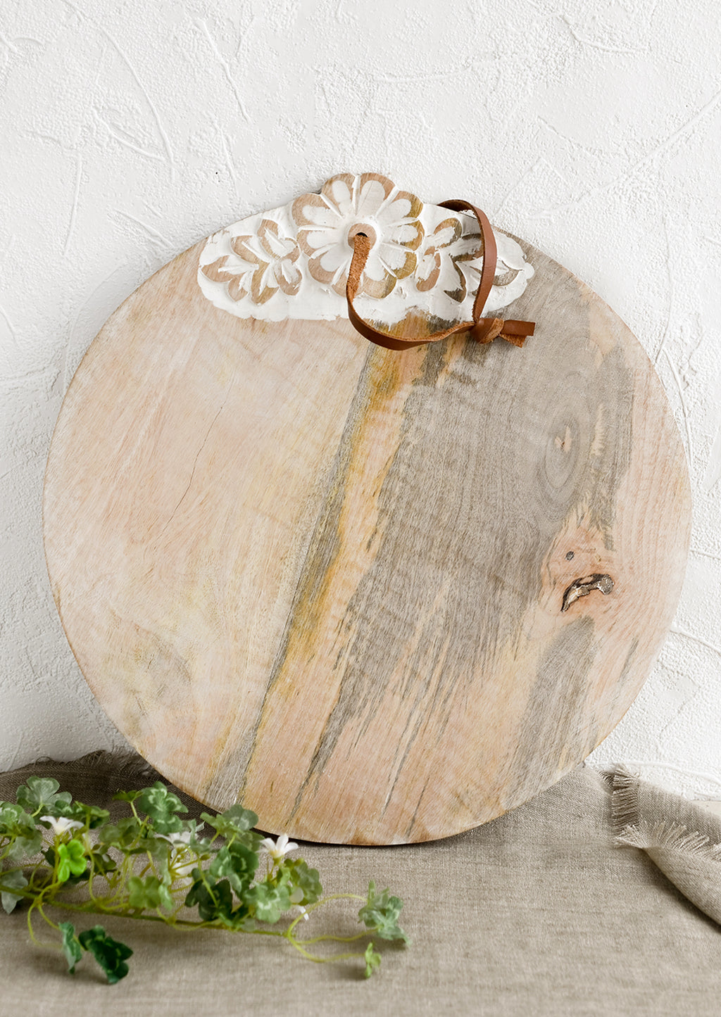 1: A round wooden cutting board with shabby chic floral detailing.