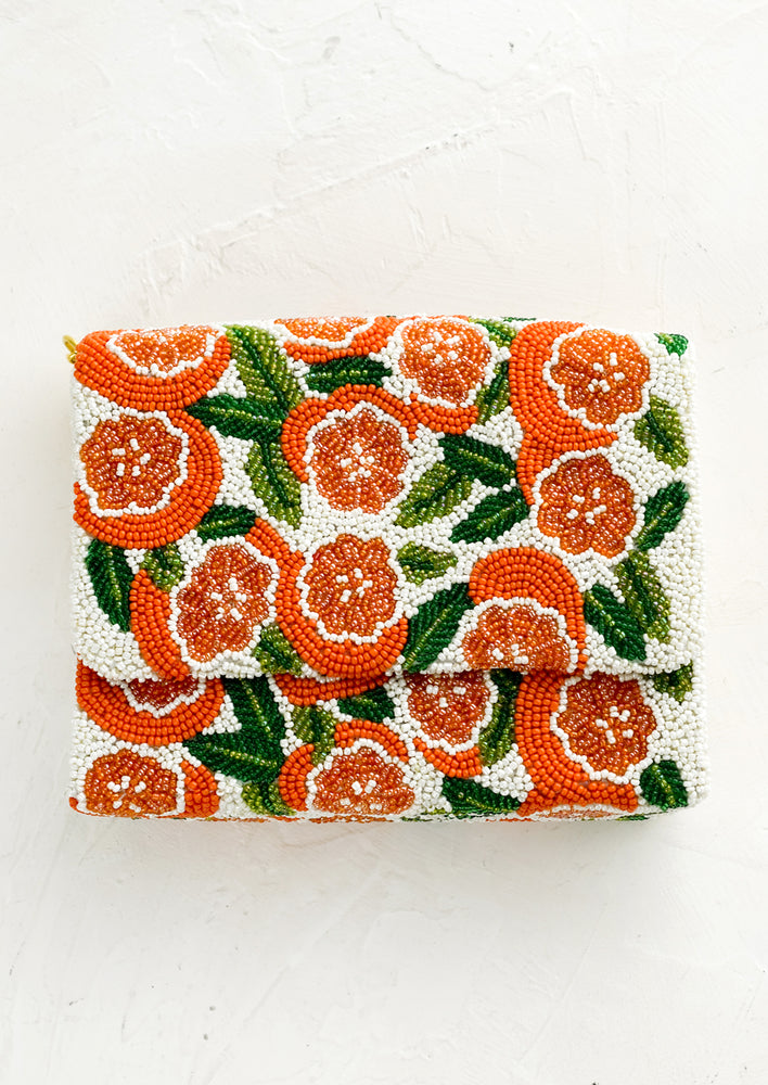 A beaded box-shaped clutch with orange citrus print.