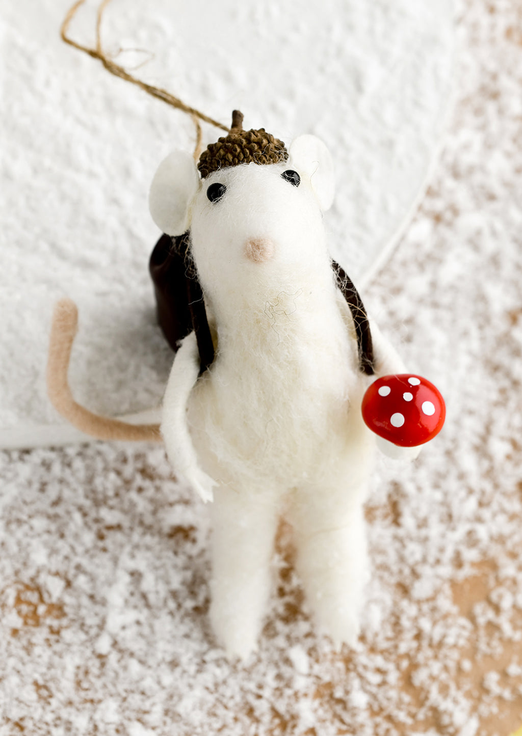 1: A felted holiday ornament of a mouse holding a mushroom.
