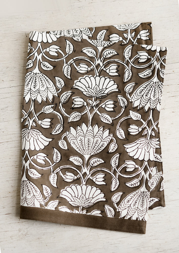 1: A dark brown and white lotus printed tea towel.