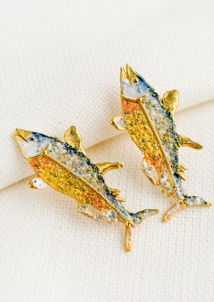A pair of hand painted earrings in tuna fish shape.