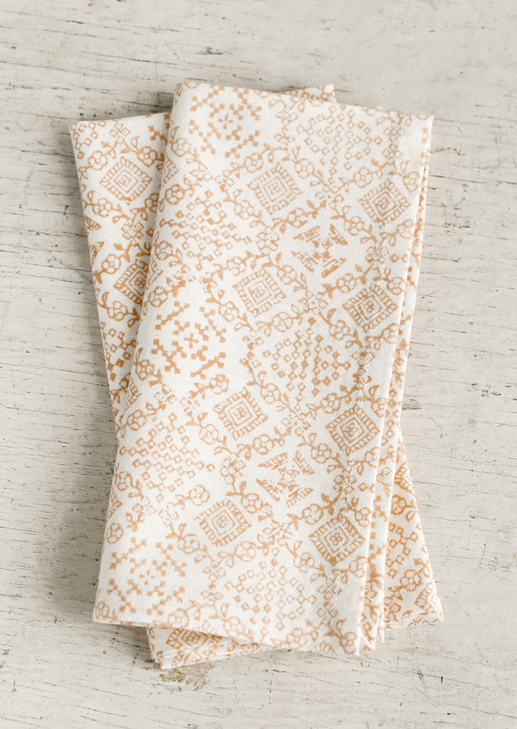 Pink Clay: A pair of cream napkins with peach tile print.
