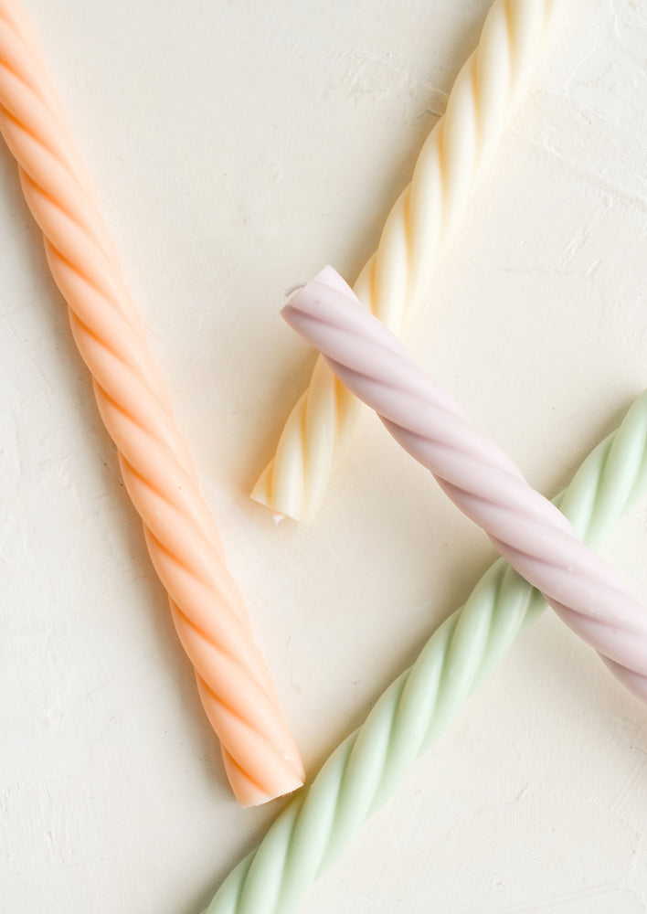 Four taper candles with twisted wax design in assorted colors.