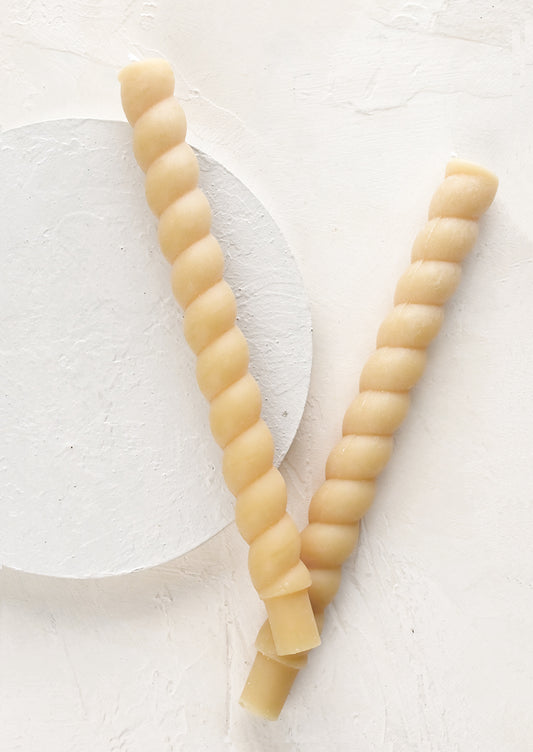 Two twisted taper candles in ivory.