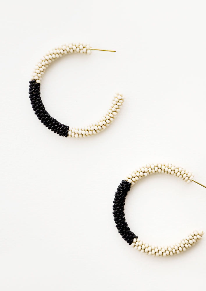 Black and ivory colorblock beaded hoop earrings.