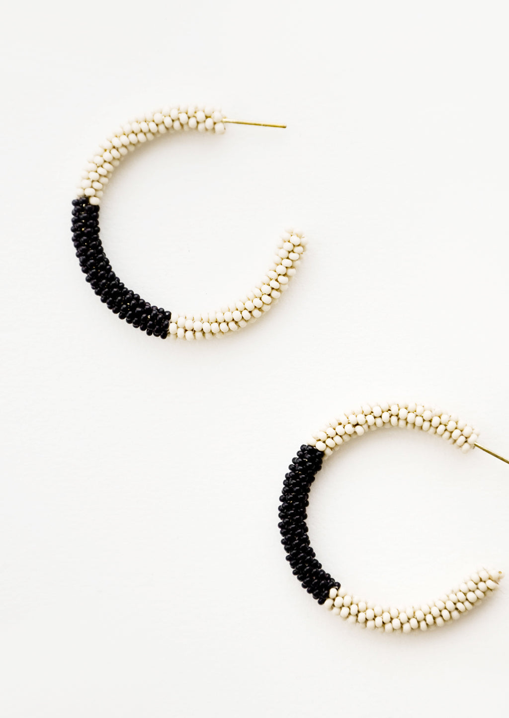 Ivory / Onyx: Black and ivory colorblock beaded hoop earrings.