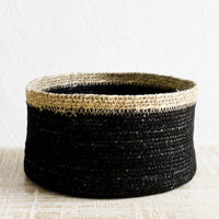 2: A shallow circular basket in black with tan rim.