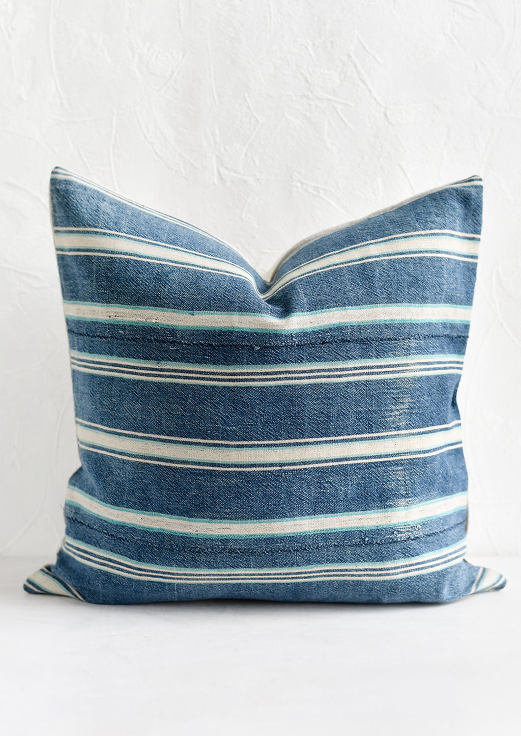 1: A square throw pillow in vintage indigo stripe fabric.