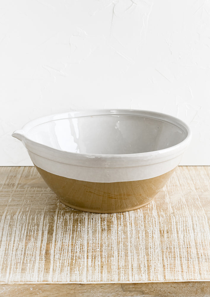 A ceramic bowl with white and brown two tone.