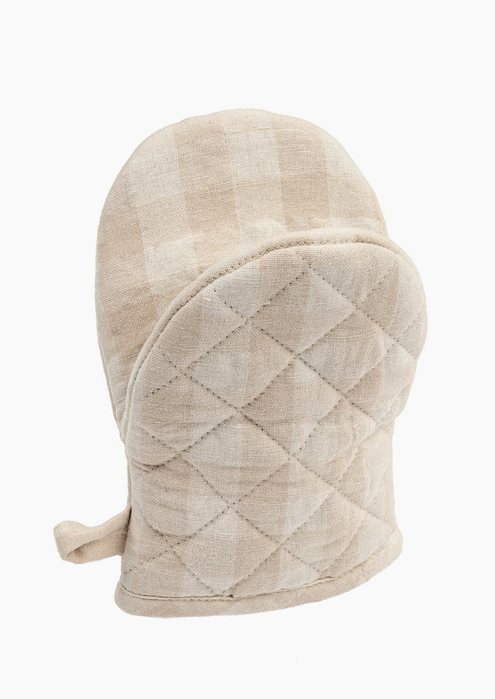 A gingham oven mitt in pale oat colorway.
